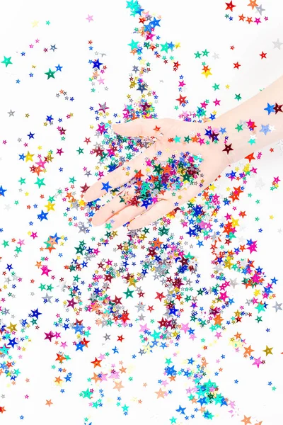 お祝いの色の星の紙吹雪と女性の手 — ストック写真