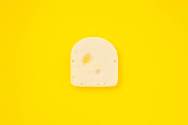 Stukje kaas op gele kleur achtergrond — Stockfoto
