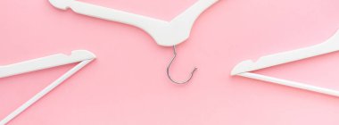 Pastel pembe arka planda beyaz askılar