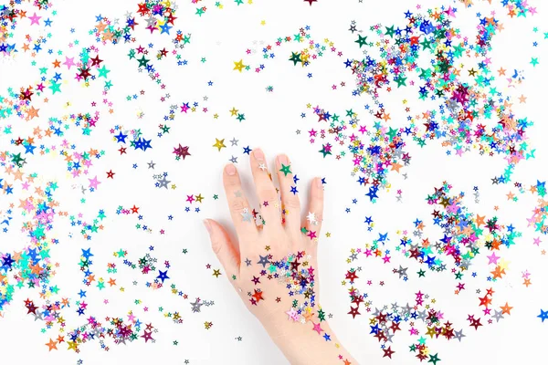 Mujer mano con color festivo estrella confeti — Foto de Stock