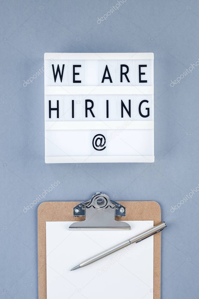 We are hiring flat lay on blue background