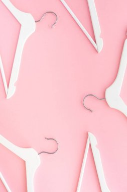 Pastel pembe arka planda beyaz askılar