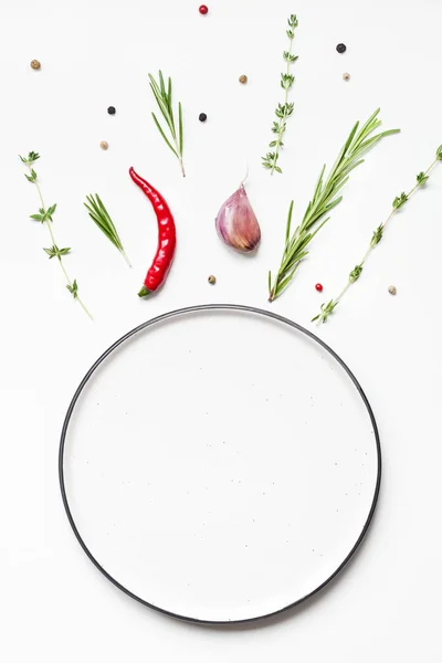 Empty plate with greens herbs and spices around — Stock Photo, Image