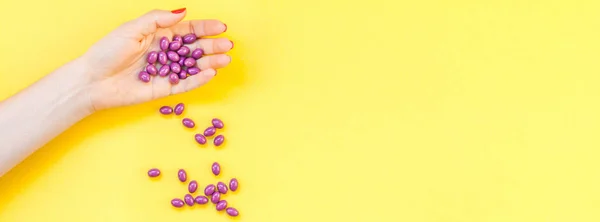 Mujer mano sosteniendo píldoras púrpura puñado — Foto de Stock