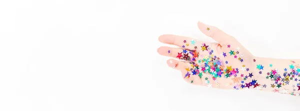 Mujer mano con color festivo estrella confeti — Foto de Stock