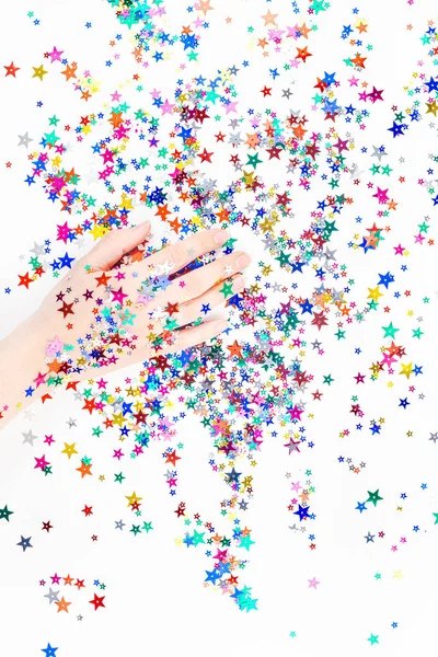 Woman hand with festive color star confetti