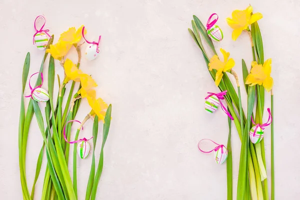 Yellow daffodil and easter eggs on pink background — Stock Photo, Image