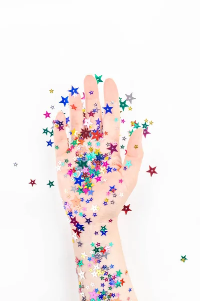 Mulher mão com cor festiva estrela confetti — Fotografia de Stock