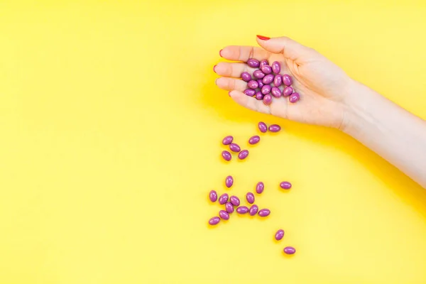 Mujer mano sosteniendo píldoras púrpura puñado — Foto de Stock