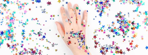 Ženská ruka s sváteční barevnou hvězdicí konfety — Stock fotografie