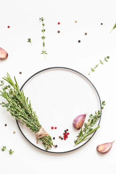 Lege plaat met groene kruiden en specerijen rond — Stockfoto