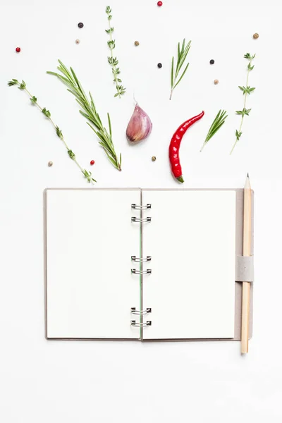 Blank notepad pages with greens herbs and spices