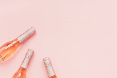 Pembe arka planda gül şampanya şarap şişesi