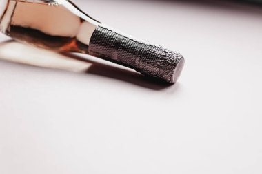 Pembe arka planda gül şampanya şarap şişesi
