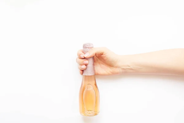 Butelka szampana różowe wino w ręce kobiety — Zdjęcie stockowe
