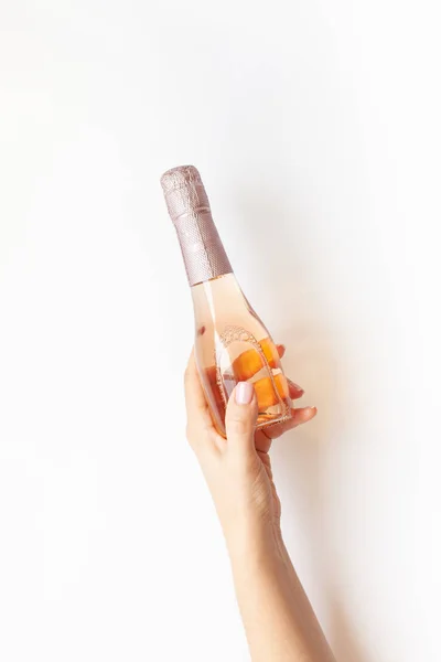 Garrafa de vinho de champanhe rosa na mão da mulher — Fotografia de Stock