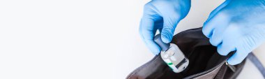 Coronavirus COVID 19 salgını sırasında lateks eldiven takan adamın elinde el hijyen jeli şişesi var. Sağlık ve güvenlik önlemleri