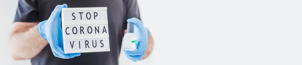 在Coronavirus Covid 19流感大流行期间 手卫生酒精凝胶瓶和装有文字的灯箱 在戴乳胶医用手套和防护面罩的男性手中拦住Coronavirus 保健服务 — 图库照片