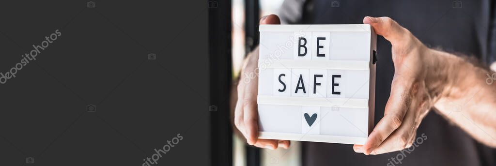 Healthcare and Safety concept. Unrecognised man holding lightbox with text Be safe during coronavirus COVID-19 pandemics