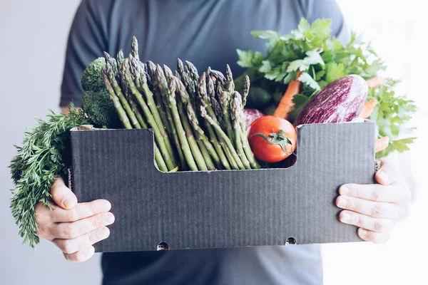 新鮮な有機野菜や野菜の配達 農家のバイオ作物と男の手を保持ボックスは 家の戸口に配信します 小さな地元のビジネスサポート オンライン食料品店 — ストック写真