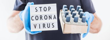 El hijyen önleyici alkol jeli şişeleri ve ışık kutusu. Coronavirus 'u durdurun. Koronavirüs COVID 19 salgını sırasında lateks eldiven ve koruyucu maske takan adamın ellerinde. Sağlık Hizmetleri