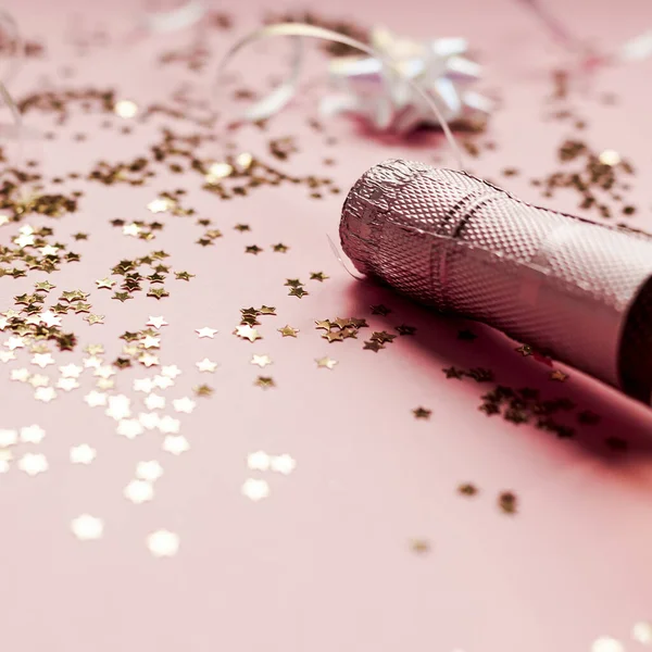 圣诞或新年的作曲 瓶装玫瑰香槟和金光闪闪的星光 粉红的背景 侧面的观点 庆祝派对创意概念 — 图库照片