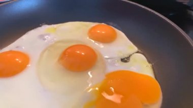 Sabah kahvaltısı için tavada ev yapımı yumurta pişirmek. 4k yemek pişirme videosu