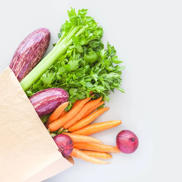 フラットレイアウトでエコクラフト紙のショッピングバッグで新鮮な有機野菜 灰色の背景にコピースペースとトップビュー 持続可能なライフスタイル 廃棄物ゼロ プラスチックフリー ケアパッケージ 寄付コンセプト — ストック写真