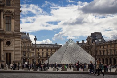 PARIS, FRANCE - 30 Eylül 2016: Louvre Sarayı ve Louvre Piramidi önünde turistler. Louvre Müzesi dünyanın en büyük ve en çok ziyaret edilen müzelerinden biridir..