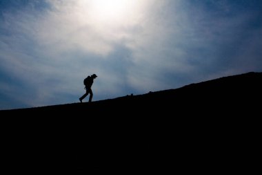 Üstünde belgili tanımlık tepe, yürüyen turist siluet