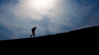 Üstünde belgili tanımlık tepe, yürüyen turist siluet