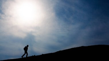 Üstünde belgili tanımlık tepe, yürüyen turist siluet