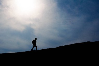 Üstünde belgili tanımlık tepe, yürüyen turist siluet