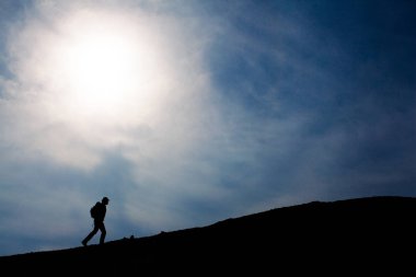 Üstünde belgili tanımlık tepe, yürüyen turist siluet