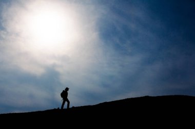 Üstünde belgili tanımlık tepe, yürüyen turist siluet