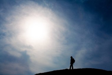 Üstünde belgili tanımlık tepe, yürüyen turist siluet