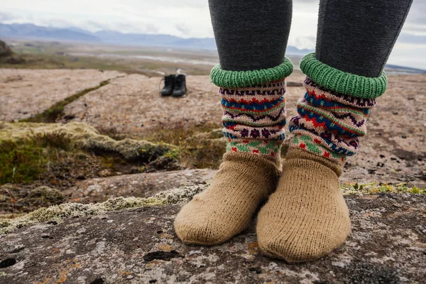 Legs in socks with beautiful ornament , on the Iceland nature and moss