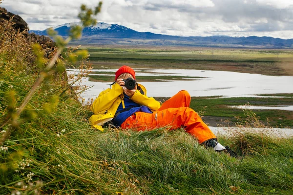 快乐的年轻女人 穿着亮晶晶的衣服 带着照相相机在冰岛旅行 享受大自然的欢愉 — 图库照片