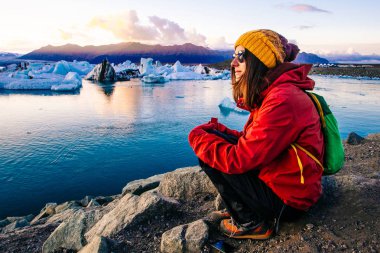 Kadın buzul Lagoon, Islandı yakınındaki parlak kırmızı spor ceketli