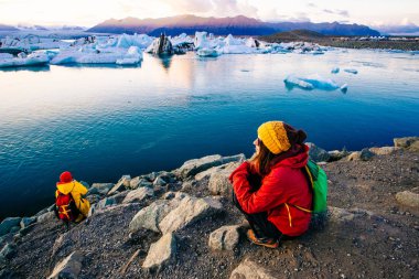 Kadın buzul Lagoon, Islandı yakınındaki parlak kırmızı spor ceketli