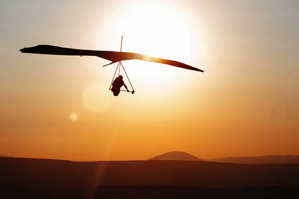 Hang-glider  flight in sky in sunset time over the