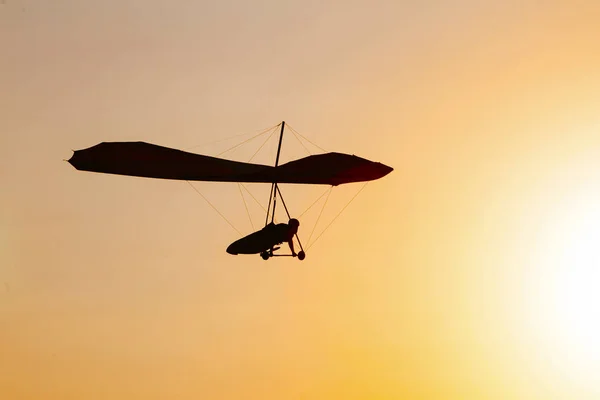 Silhueta de asa-delta no céu ao pôr-do-sol — Fotografia de Stock