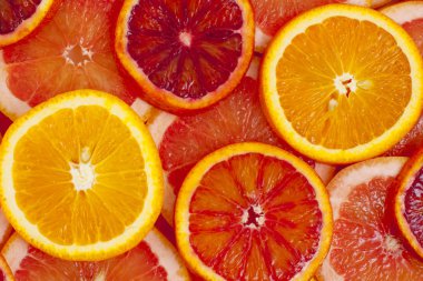 Farklı türde portakal ve greyfurt dilimleri arka planda