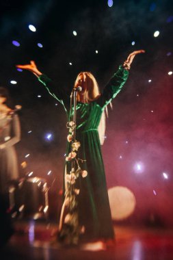 Genç sarışın kadın şarkıcı konser ışık