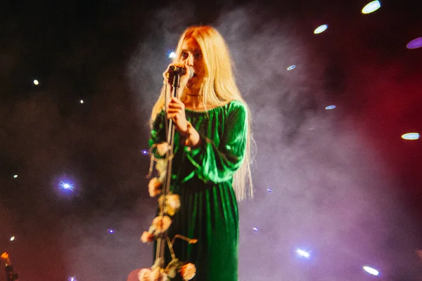 Young blond woman singer in concert light