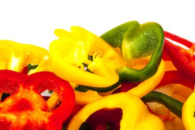 Beyaz arkaplanda izole edilmiş üç renkten oluşan pebiber dilimleri