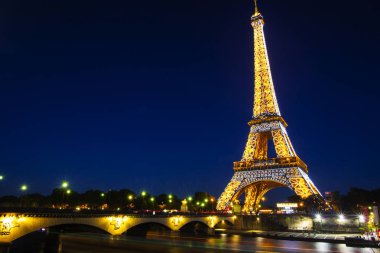 Paris-4 Ekim. Işık performans gösterisi Ekim 4, 2016 Paris 'te. Eiffel Kulesi 324 metre (1.063 ft) boyunda duruyor. Anıt 1889 yılında inşa edildi, yen Köprüsü gece görünümü