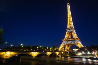 Paris-4 Ekim. Işık performans gösterisi Ekim 4, 2016 Paris 'te. Eiffel Kulesi 324 metre (1.063 ft) boyunda duruyor. Anıt 1889 yılında inşa edildi, yen Köprüsü gece görünümü