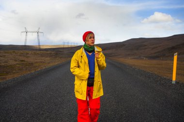 Mutlu turist kadın parlak giysiler ve sarı ceket, zevk
