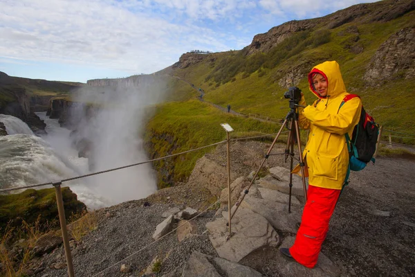 Γυναίκα με φωτεινά κίτρινα και κόκκινα ρούχα φτιάχνοντας φωτογραφίες σε εκπληκτική — Φωτογραφία Αρχείου